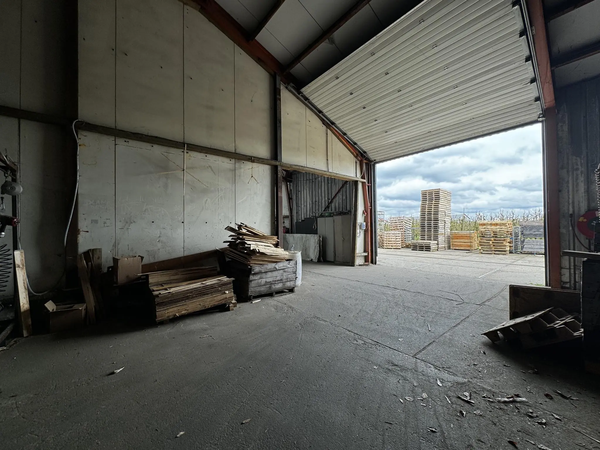 Open loods aan de Graaf van Lynden van Sandenburgweg met stapels houten pallets binnen en buiten.